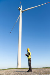 Engineer with digital tablet controls wind turbines