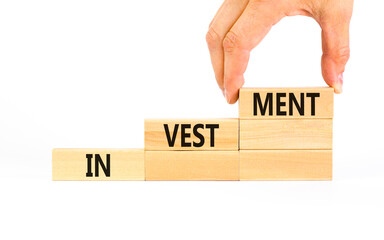 Investment symbol. Concept word Investment on beautiful wooden blocks. Businessman hand. Beautiful...