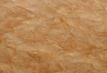 Obraz premium A textured background featuring crumpled, wrinkled paper in warm beige tones. The surface has a natural, organic feel, ideal for artistic or design purposes.