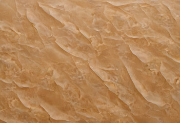 A textured background featuring crumpled, wrinkled paper in warm beige tones. The surface has a natural, organic feel, ideal for artistic or design purposes.