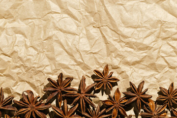 Anise stars pattern, above view close up flavor spices dried anise seeds on paper, still life with natural condiments, aromatic ingredient for cooking, rustic style food background, gastronomy theme
