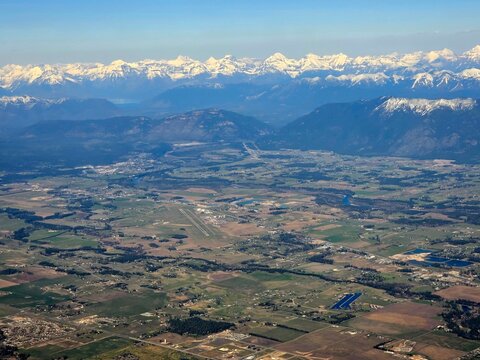 Aerial view of Kalispell, Montana with snow capped peaks of Glacier Park in the background