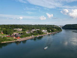 Aerial of the Niagara River and a boat at the village of Lewiston and the international border with Canada Queenston-Lewiston bridge in New York, United States, on a summer afternoon in July, 2024.
