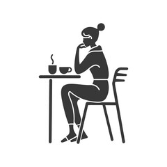 Woman Sitting at Table with Coffee and Hand on Chin