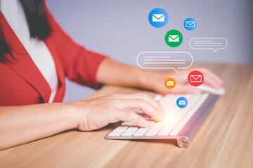 Businesswoman using keyboard to type messages and send emails.