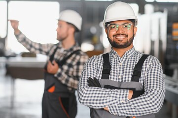 Two engineer worker working together with safety uniform and white helmet to work in industry factory