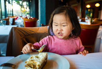 girl are sitting at a table with a plate of cake in front of them