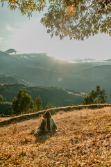 persona de espaldas viendo hacia el horizonte frente a una montaña en un amanecer 