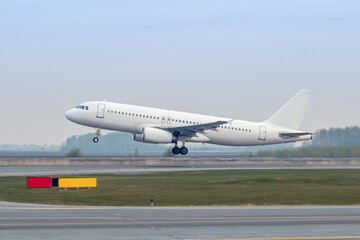 Modern white passenger jetliner takes off runway