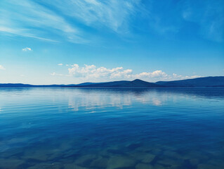 The blue surface of the water, the sky with clouds on the horizon of the mountain. The natural landscape. Lake Turgoyak