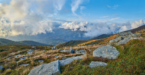 A breathtaking panorama of a mountain landscape with rolling hills covered in autumn foliage,...