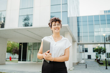 Young successful woman is going to work at modern business building