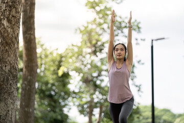 Young Healthy Woman Practicing Yoga Outdoors in a Park, Embracing Fitness and Wellness in a Natural Green Environment