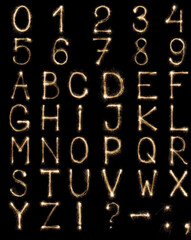 Full english alphabet and numbers set made from burning sparkles on black background. Shiny festive firework latin font.