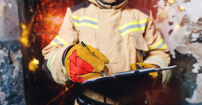Fireman inspector uses clipboard and conducts investigation to determine circumstances of fire in house. Insurance incident survey concept