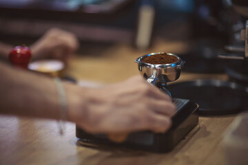 Weighing coffee on scales for better proportion. barista weighing coffee in a portafilter. cafe,...