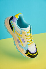 White sneaker with colored accents on bright background, Fashionable sport shoe with colorful...