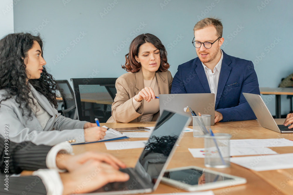 Leinwandbilder a group of business professionals sit around a conference table in a modern office. they are engaged
