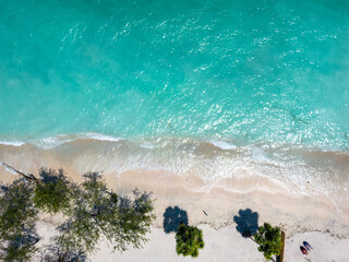 Tropical beach vacation concept image with a couple sunbathing. taken on Gili Island beach, aerial landscape by drone in Indonesia