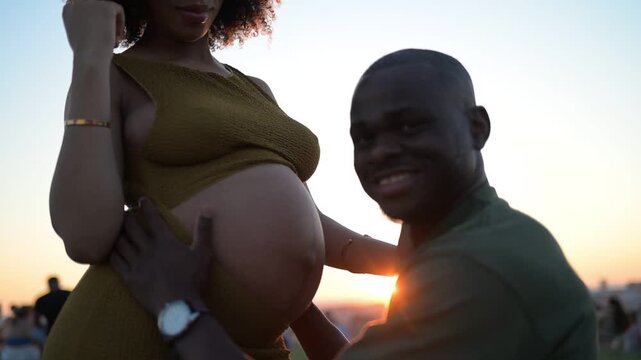 A Joyful Expecting Couple Embracing the Beauty of Sunset and Parenthood