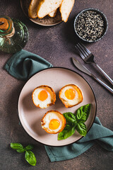 Baked egg and bacon rolls with basil on a plate on a table top and vertical view