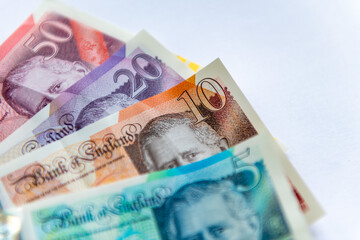 Updated Pound Sterling bank notes with the King's portrait isolated in a white background.