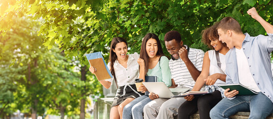 Exam Results. Group Of Joyful International Students Celebrating Success With Laptop Outdoors, Checking Their Test Scores Online