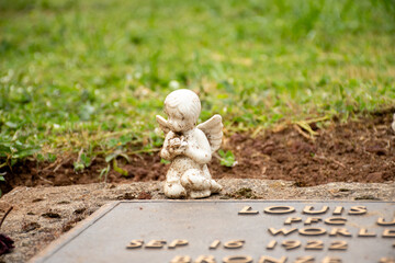 Obraz premium Serene White Cherub Statue on a Headstone
