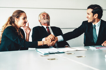 Senior old executive manager working with young businesspeople in office meeting room. Old man is company leader sitting with secretary and translator. International corporate business concept. uds