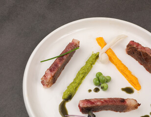 Plate Presentations , Goat steak with peas, green leaves and mushrooms