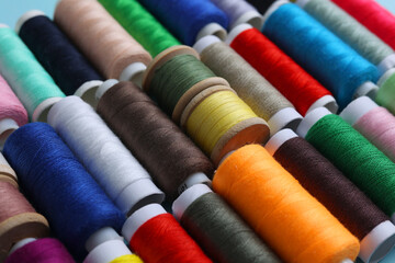 Threads for sewing in different colors on a colored background
