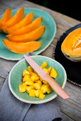 table with bowl with cut peach pieces and melon slices on top. selective focus