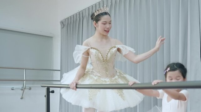Ballet class, toddler girl in ballet clothes practicing ballet dance with teacher, standing next to the ballet practicing bar, child development skill, modern arts performance lesson for child