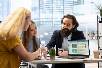 Financial advisor presenting financial strategies to customers, recommending stock market bonds. Broker in office assisting clients with forex investment portfolio management