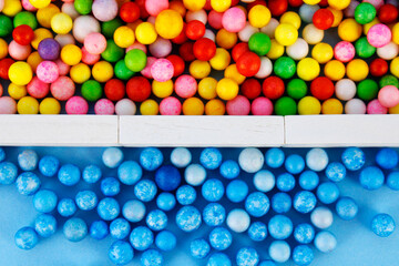 Blue spheres separated from other spheres of different colors by a wall made of rectangular wooden figures