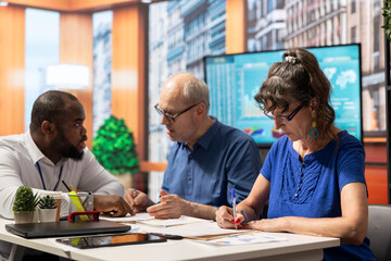 Elderly people signing the retirement plan contract in a meeting with adviser, choosing the perfect investment to secure their pension and future income. Sign the document terms.