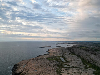 Aerial shot of the red granite coastline of Bohuslän, Sweden during sunset.