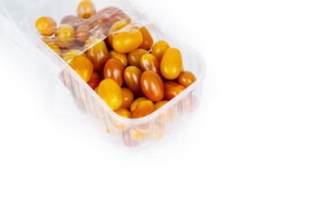 Fresh orange grape tomatoes packed in a clear plastic container. Vegetables convenient packaging. Perfect for snacking. Closeup. Isolated on white background. Copy space..