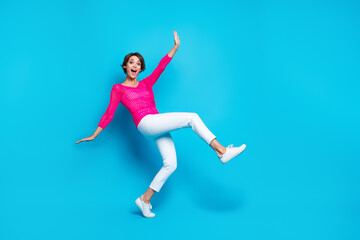 Full length photo of excited funky lady dressed pink knitted shirt walking dancing empty space isolated blue color background