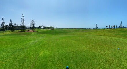Fototapeta premium Panorama view of Golf Course with fairway field. Golf course with a rich green turf beautiful scenery.