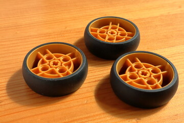 Plastic toy wheels on wooden background.