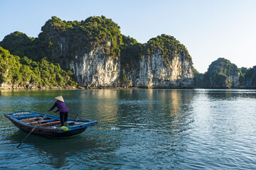 Señora remando en barca en bahía de Halong, Vietnam