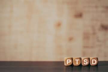 There is wood cube with the word PTSD. It is an abbreviation for Post-Traumatic Stress Disorder as eye-catching image.