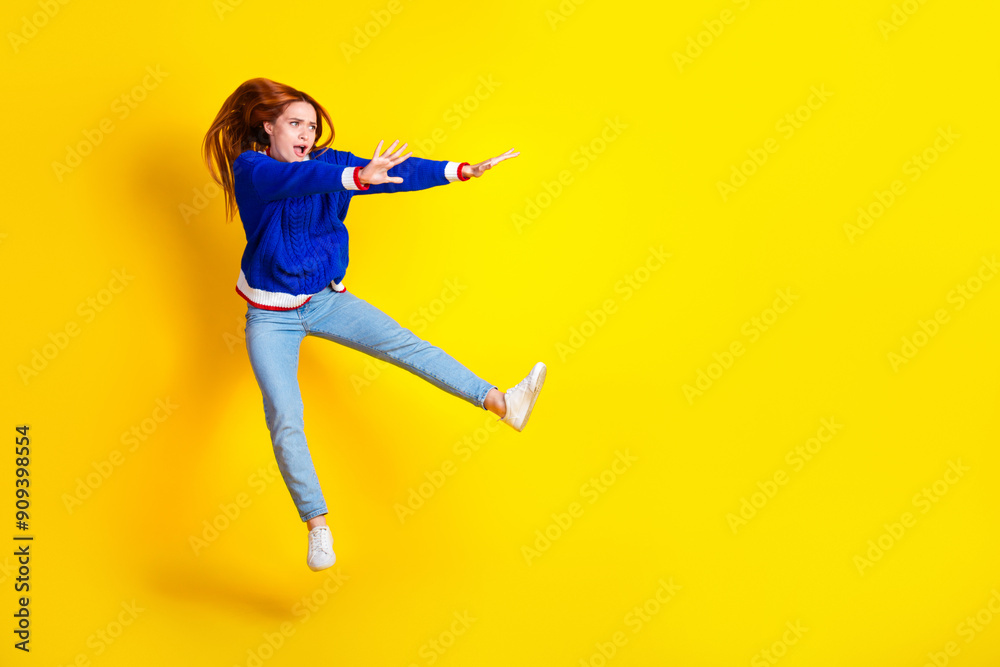 Canvas Prints photo of red hair jumping model young cheerful woman in blue stylish pullover and jeans pushing empt