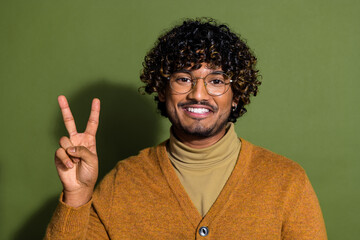 Photo portrait of pretty young male show v-sign wear trendy brown outfit isolated on khaki color background