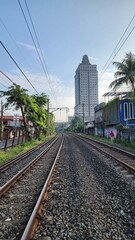 A picturesque rail road landscape in Indonesia, featuring lush greenery, rolling hills, and vibrant skies. The scenic view captures the natural beauty and tranquil charm of the Indonesian countryside.