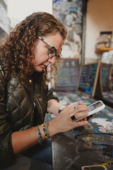 Young woman texting on her phone  on a coffee shop.