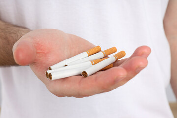 Cigarettes in a man's hand on a light background