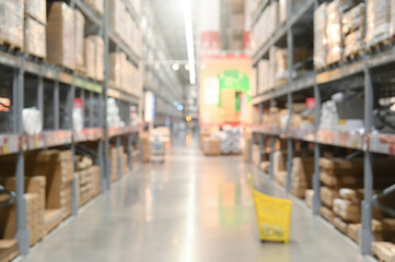 Blurry perspective of a large warehouse aisle with shelves stacked with boxes and goods.