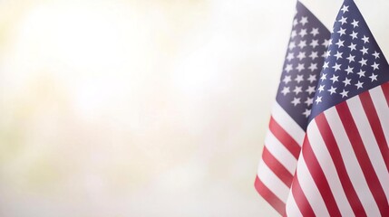 Fototapeta premium Two American flags waving in the wind against a bright, blurred background.